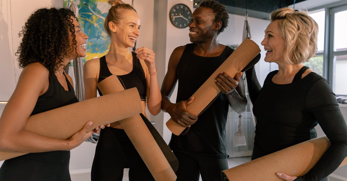 Group of smiling adults holding yoga mats, embracing fitness and wellness indoors.